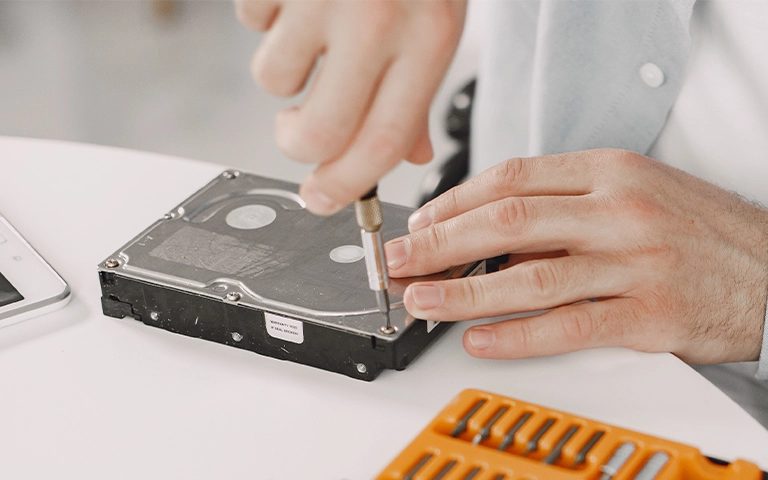 Tornavidayla hard disk gövdesini açmaya çalışan kişi