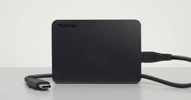 USB-C kablosuyla bağlı siyah Toshiba harici disk masanın üzerinde