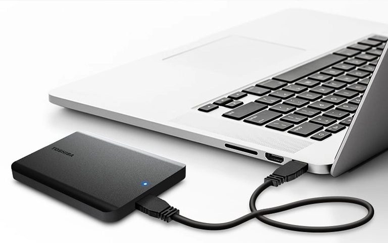 USB kablosuyla dizüstü bilgisayara bağlı siyah Toshiba harici disk